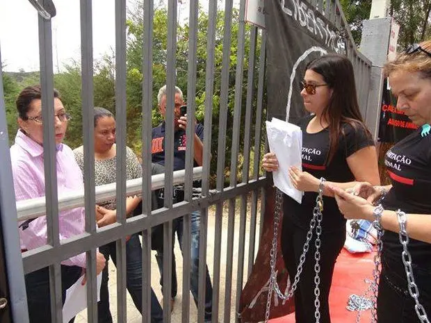 Ativistas permanecem acorrentados ao portão no terceiro dia de protestos (Foto: Marcelo Barbosa dos Santos)