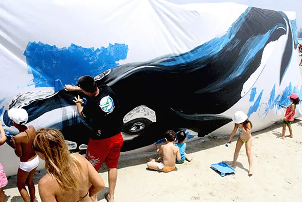 De forma voluntária, Alexandre Huber pinta baleia gigante com crianças em Santos (SP). (Foto: Waves)