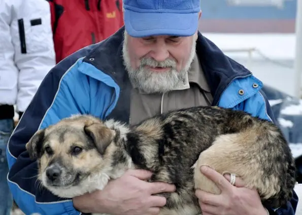 O marinheiro Adam Buczynski segura o cão Báltico em foto desta terça-feira (26). (Foto: AP)