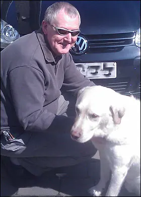 foto do cão guia ao lado de seu tutor cego