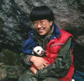 foto da bióloga segurando um bebê panda
