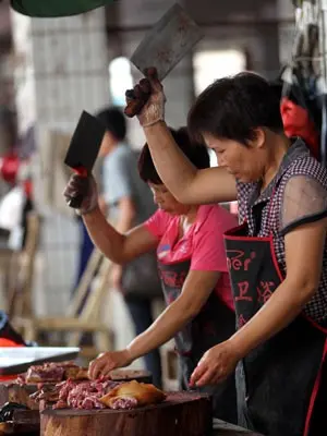  Fornecedores cortam a carne em mercado popular de Yulin (Foto: Humane Society International/ AP)
