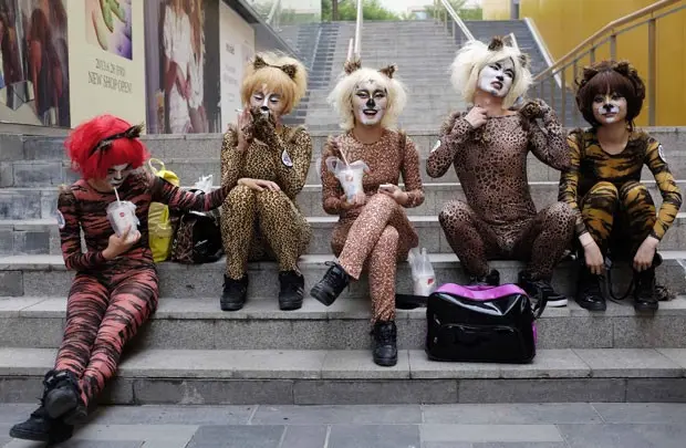 Ativistas vestidas com roupas que lembram animais fazem performance em Pequim nesta quinta-feira (20) pedindo a proteção dos cães (Foto: Jason Lee/Reuters)
