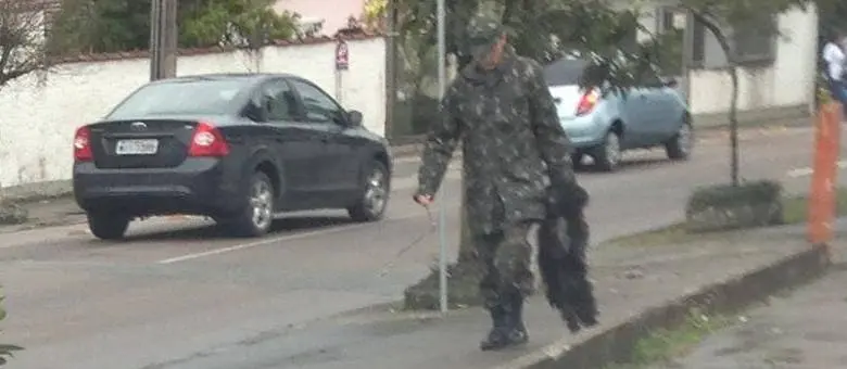 Militar alegou que carregou cão dessa forma porque ele estava sujo (Foto: Reprodução Facebook)