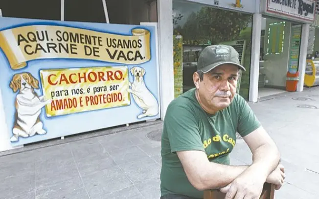 Iguaci Moraes, dono da lanchonete, em frente a placa Foto: João Laet / Agência O Dia
